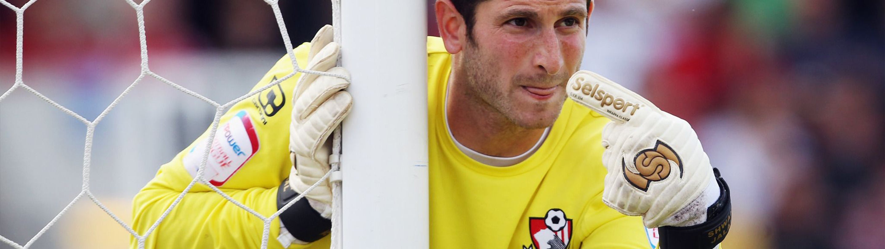 Shwan Jalal International goalkeeper for Iraq in yellow Chesterfield goalkeeper shirt pointing to his goal in Seslport goalkeeper gloves