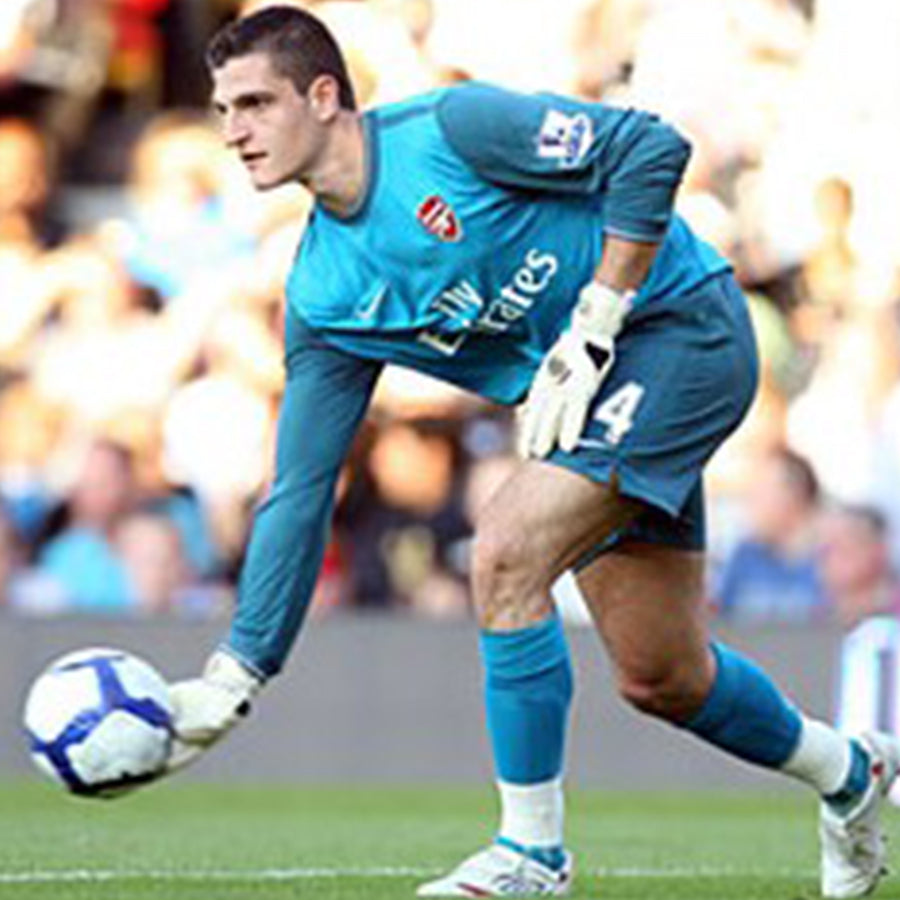 Vito Mannone goalkeeper for Arsenal wearing blue arsenal kit about to roll a football out wearing Selsport goalkeeper gloves