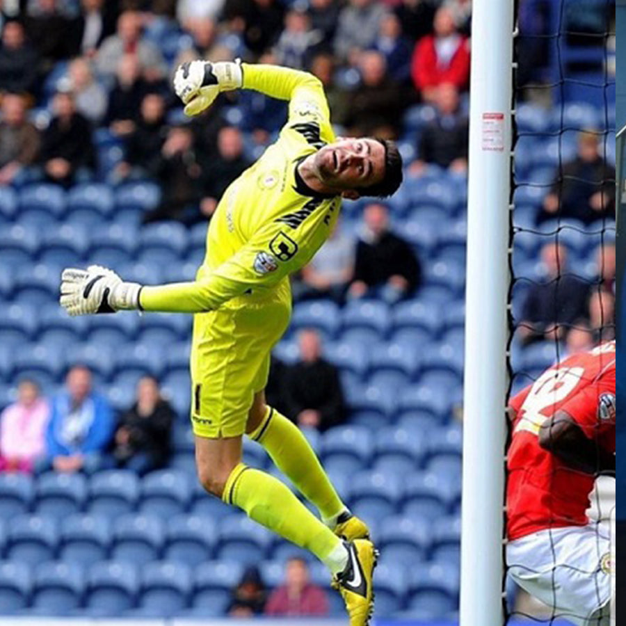 Steve Phillips in yellow goalkeeper kit mid air diving across the goal making a save in selsport Eurowrap goalkeeper gloves