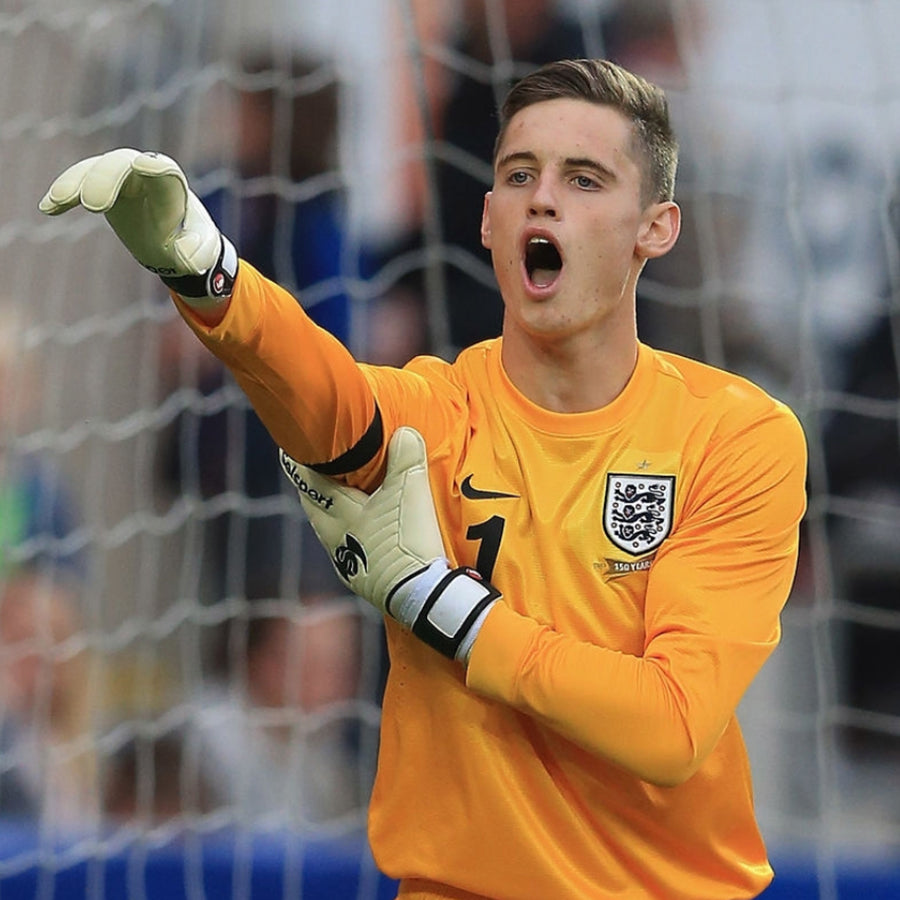 Ted Smith England goalkeeper wearing yellow England Kit in gola holding one are by his elbow  in Selsport goalkeeper gloves