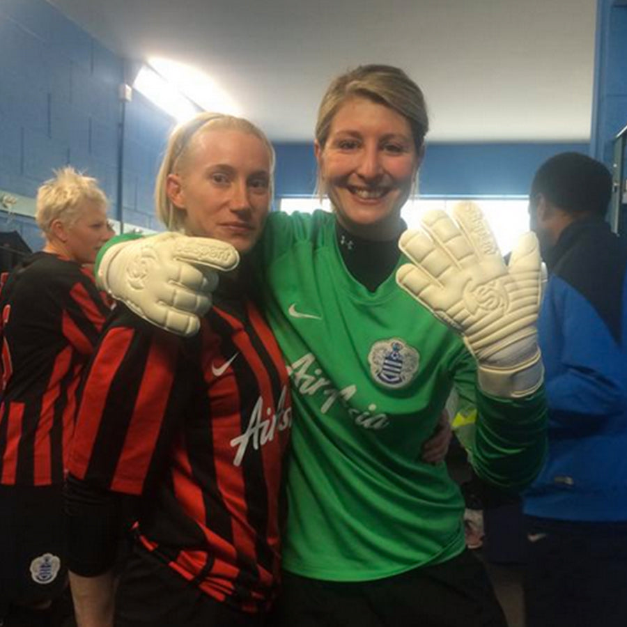 Trippoli Witney in a green QPR goalkeeper shirt hugging a player showing her selsport gloves to the camera