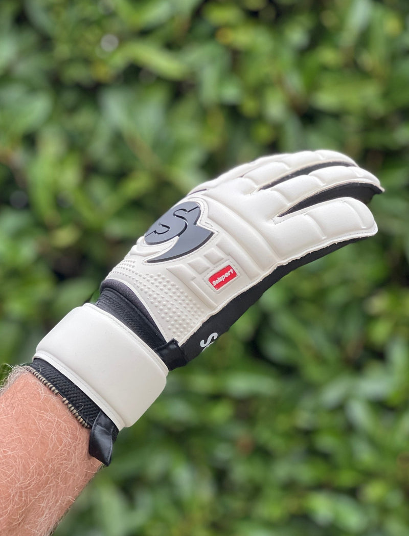 Selsport white & Black goalkeeper  glove with  branded logo on a blurred green background