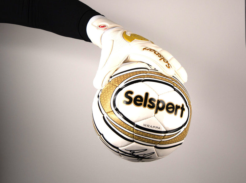 Selsport Professional Goalkeeper glove Wrappa Classic EA+ Gold holding a football