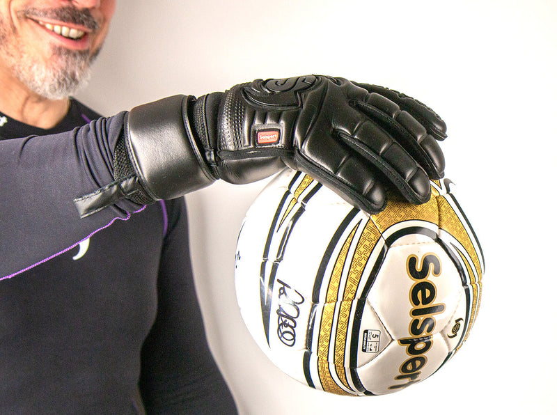 Selsport Wrappa Classic Professional Rollfinger goalkeeperglove in all black with pro wrist strap with one hand holding a ball