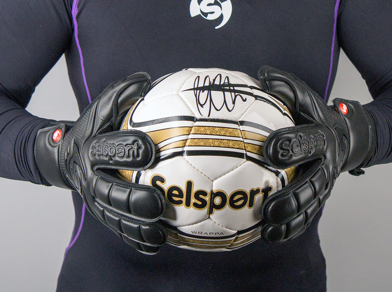 Selsport Wrappa Classic Professional Rollfinger goalkeeperglove in all black with pro wrist strap both hands on a selsport football